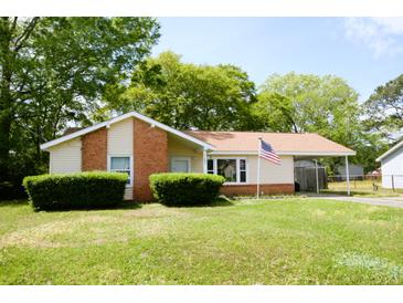 Charming single-story home featuring a manicured lawn, inviting curb appeal, and a convenient covered carport at 7605 Ireland Dr, North Charleston, SC 29420