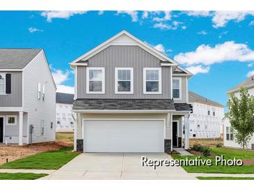 Charming two-story home with gray siding, a two-car garage, and a well-manicured lawn on a sunny day at 1008 Drakeford St # 4P, Saint George, SC 29477