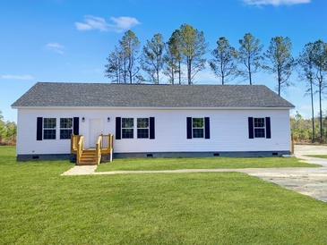 Charming single-story home with white siding and a well-manicured lawn at 117 Dotson St, Harleyville, SC 29448