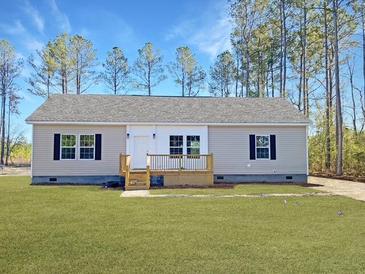 Charming single-story home with neutral siding, a well-manicured lawn, and a cozy front porch at 121 Dotson St, Harleyville, SC 29448