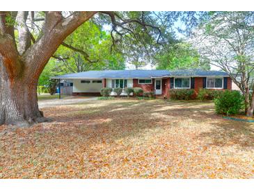 Charming red brick house featuring mature trees, large front yard, and inviting curb appeal at 1318 Foster St, Charleston, SC 29407