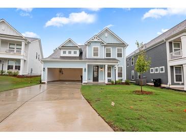 Charming light blue two-story home with an attached garage and a well-manicured lawn at 355 Wappoo Trace Ln, Summerville, SC 29486
