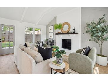 Bright living room with whitewashed brick fireplace, beamed ceiling, and stylish decor at 5573 Betty Ct, North Charleston, SC 29418