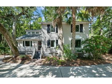 Exterior featuring a well-maintained home surrounded by mature trees and lush landscaping at 597 Oyster Rake Dr, Kiawah Island, SC 29455