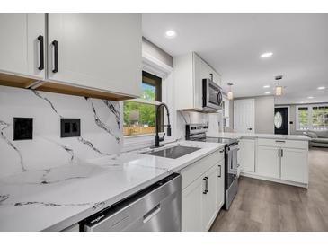 Modern kitchen features white cabinets, quartz countertops, stainless steel appliances, and a stylish backsplash at 1249 Sumner Ave, North Charleston, SC 29406
