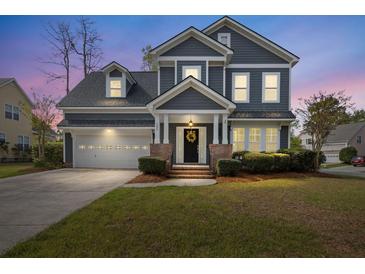 Charming two-story home with a well-manicured lawn, a welcoming front porch, and an attached two-car garage at 135 Marshside Dr, Summerville, SC 29485
