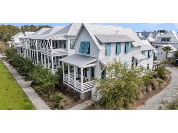 Charming coastal home with white siding, blue shutters, and a inviting front porch with seating at 1466 Mizzen Aly, Johns Island, SC 29455