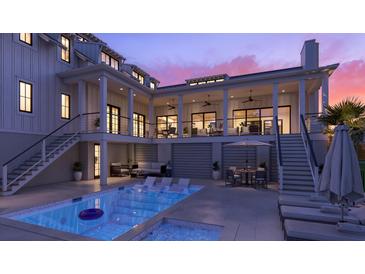Inviting pool area with lounge chairs, outdoor seating, and well-lit porch overlooking the sparkling blue water at 1715 Middle St, Sullivans Island, SC 29482