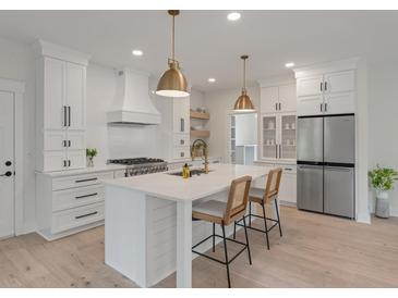 Bright kitchen with white cabinets, subway tile backsplash, stainless appliances, and brass pendant lights at 2226 Red Fern Lane, Mount Pleasant, SC 29466