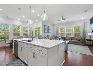 Bright kitchen with quartz counters, large windows, pendant lights, stainless appliances, and adjacent sitting and living areas at 3010 Emma Ln, Mount Pleasant, SC 29466