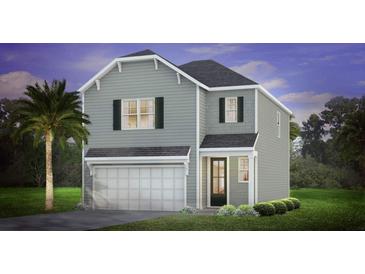 Charming two-story home featuring gray siding, a front-entry garage, and a well-manicured lawn at 348 Dickerson Ln, Lincolnville, SC 29485