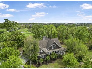 Stunning exterior view of a beautifully landscaped home surrounded by lush greenery and a golf course backdrop at 126 Balfour Dr, Charleston, SC 29492