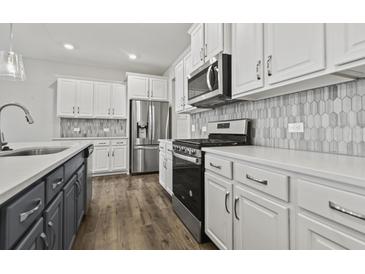 Modern kitchen features white cabinets, stainless steel appliances, and a stylish backsplash at 258 Godwit Dr, Summerville, SC 29486