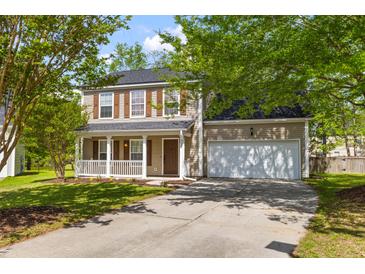 Charming two-story home with a welcoming front porch, landscaped yard, and attached two-car garage at 407 Burton Ave, Summerville, SC 29485