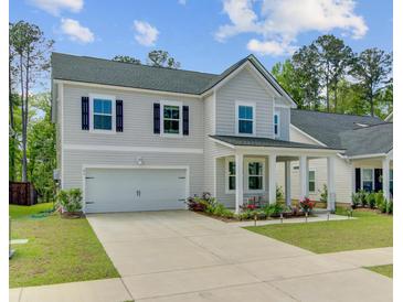 Charming two-story home boasts a two-car garage, covered porch, and beautifully landscaped front yard at 86 Red Bluff St, Summerville, SC 29483