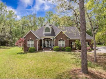 Charming brick home featuring manicured landscaping, arched windows, and a welcoming front porch at 118 Elery Ter, Summerville, SC 29485