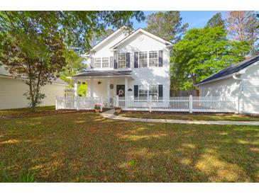 Charming two-story home with a white picket fence, a welcoming porch, and well-manicured landscaping at 144 Jupiter Ln, Summerville, SC 29483