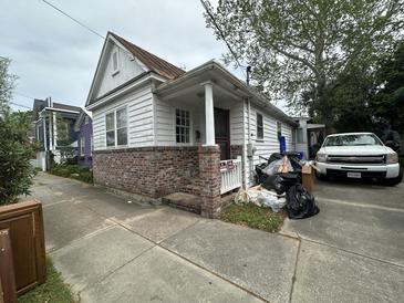 Charming single-story home with brick foundation, featuring a front porch and driveway at 227 & 229 Fishburne St, Charleston, SC 29403