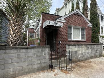 Charming brick home featuring a secure gated entrance and beautiful architectural details at 227/229/3 Fishburne/Woodall St, Charleston, SC 29403
