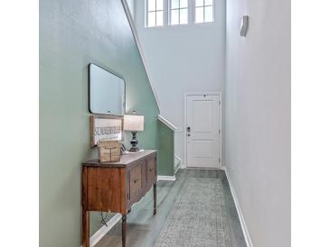 Welcoming foyer with stylish console table, mirror, and modern decor, illuminated by natural light from transom windows at 302 Fox Gap Rd, Summerville, SC 29486