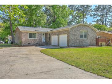 Charming brick home with a well-maintained lawn and a two-car garage at 100 Lipman St, Summerville, SC 29483