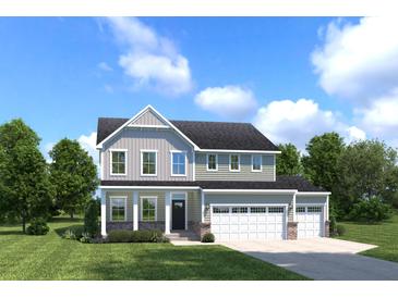 Charming two-story home featuring a spacious three-car garage and well-manicured lawn at 1015 Lacebark Dr, Ridgeville, SC 29472
