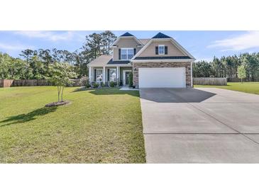 Charming two-story home featuring stone accents, a well-manicured lawn, and an attached two-car garage at 106 Lakelyn Rd, Moncks Corner, SC 29461