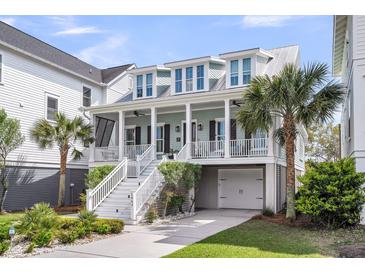 Charming two-story home features a welcoming front porch, white railing, and manicured landscaping at 1063 Hills Plantation Dr, Charleston, SC 29412