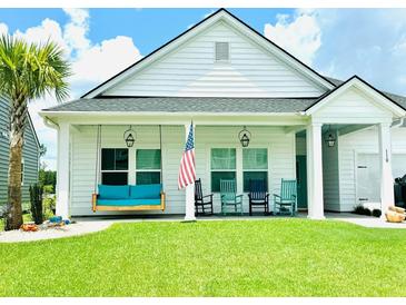 Inviting front porch features a swing, rocking chairs, and well-manicured lawn at 110 Haverhill St, Summerville, SC 29486