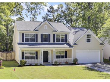 Charming two-story home featuring a welcoming front porch, well-maintained lawn, and attached garage, offering classic curb appeal at 150 Sugar Magnolia Way, Charleston, SC 29414