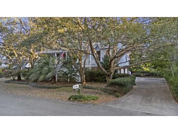 Charming two-story home with a landscaped front yard, mature trees, and a inviting driveway at 2 Wills Way, Isle of Palms, SC 29451