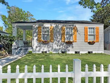 Charming home featuring three windows with stylish shutters, complemented by a white picket fence and a well-manicured lawn at 2313 Kent Ave, North Charleston, SC 29405