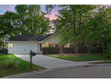 Charming single-story home with a well-maintained lawn, mature trees, and a two-car garage at 301 Huntington Ct, Hanahan, SC 29410