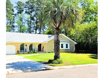 Charming brick home with lush front yard and mature palm tree for shaded curb appeal at 307 Fairington Dr, Summerville, SC 29485