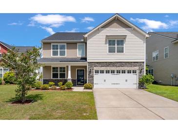 Charming two-story home with stone accents, a well-manicured lawn, and a two-car garage at 364 Deep River Rd, Summerville, SC 29486