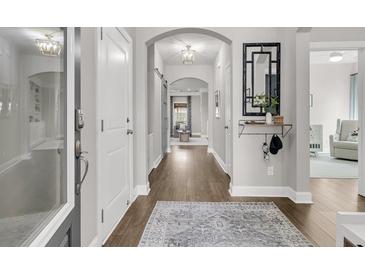 Inviting hallway features wood floors, neutral walls, and arched entryway to an open-concept living space at 3968 Hanoverian Dr, Mount Pleasant, SC 29429