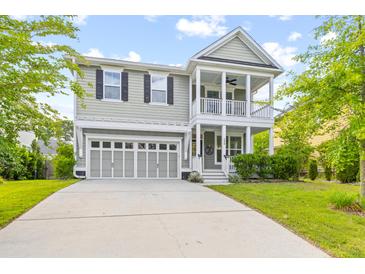 Charming home with a front porch, two-car garage, and a well-maintained lawn under a partly cloudy sky at 408 Branch Creek Trl, Summerville, SC 29483
