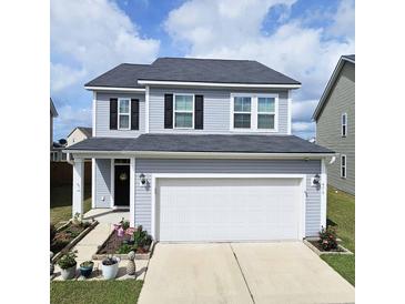 Charming two-story home featuring a well-maintained front yard, a two-car garage, and blue vinyl siding at 470 Spectrum Rd, Summerville, SC 29486
