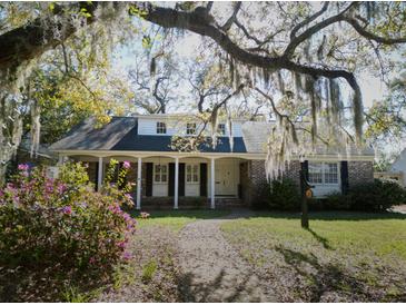 Charming brick home featuring a covered porch, dormer windows, and a well-manicured front yard at 731 Pitt St, Mount Pleasant, SC 29464