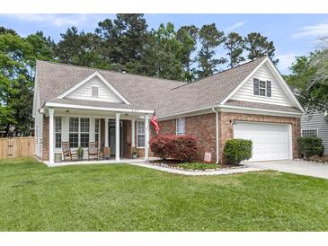 Charming brick home with a well-manicured lawn, attached garage, and inviting front porch at 117 Back Tee Cir, Summerville, SC 29485