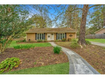 Charming single story home featuring manicured lawn, brick facade, and inviting stone walkway at 123 Tiffany Ln, Summerville, SC 29485