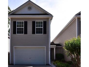 Charming home featuring a two-car garage and neatly landscaped front yard with a manicured bush near the front entrance at 1314 Garland St, North Charleston, SC 29420