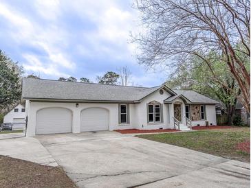 Charming brick home featuring a well-maintained lawn and a two-car attached garage at 132 Tranquil Ln, Ladson, SC 29456