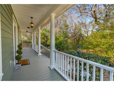 Inviting front porch featuring classic columns, pendant lighting, and views of the lush surrounding greenery at 1504 Galloway Ln, Charleston, SC 29412