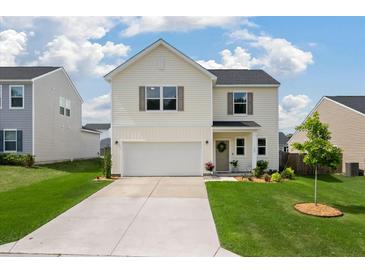 Charming two-story home featuring a two-car garage, manicured lawn, and inviting curb appeal at 163 Cypress Plantation Rd, Moncks Corner, SC 29461