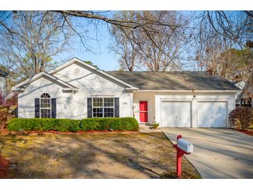 Charming single-story home featuring a red front door, attached garage, and well-maintained landscaping at 1906 Cedar Petal Ln, Charleston, SC 29414
