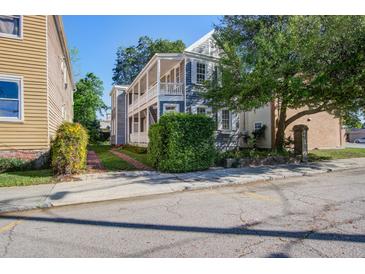 Charming two-story home features a spacious porch and landscaped yard with mature trees at 22 Ashton St, Charleston, SC 29403
