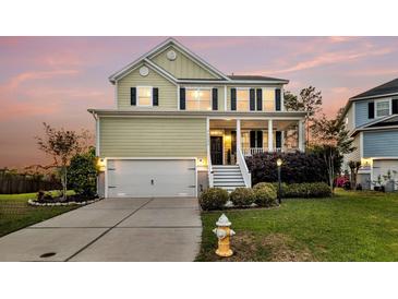 Charming two-story home with a welcoming front porch, manicured lawn, and attached two-car garage at 2242 Terrabrook Ln, Charleston, SC 29412