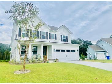 Charming two-story white home boasts a well-manicured lawn, black shutters and a two-car garage at 3025 Dewitt Ct, Hollywood, SC 29449