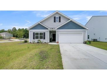 Charming single-Gathering home with blue and gray siding, a manicured lawn, and an attached garage at 309 Torslanda Ln, Summerville, SC 29486